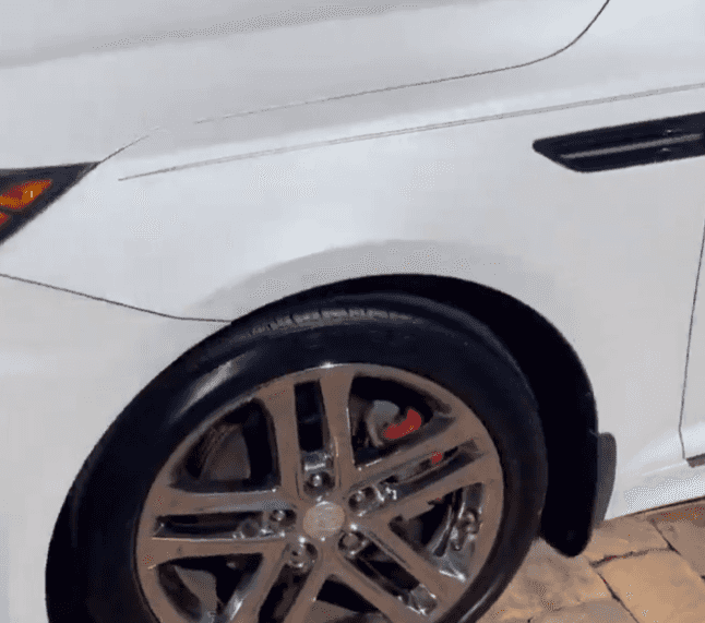 White Kia front fender, wheel, and tire after exterior detailing
